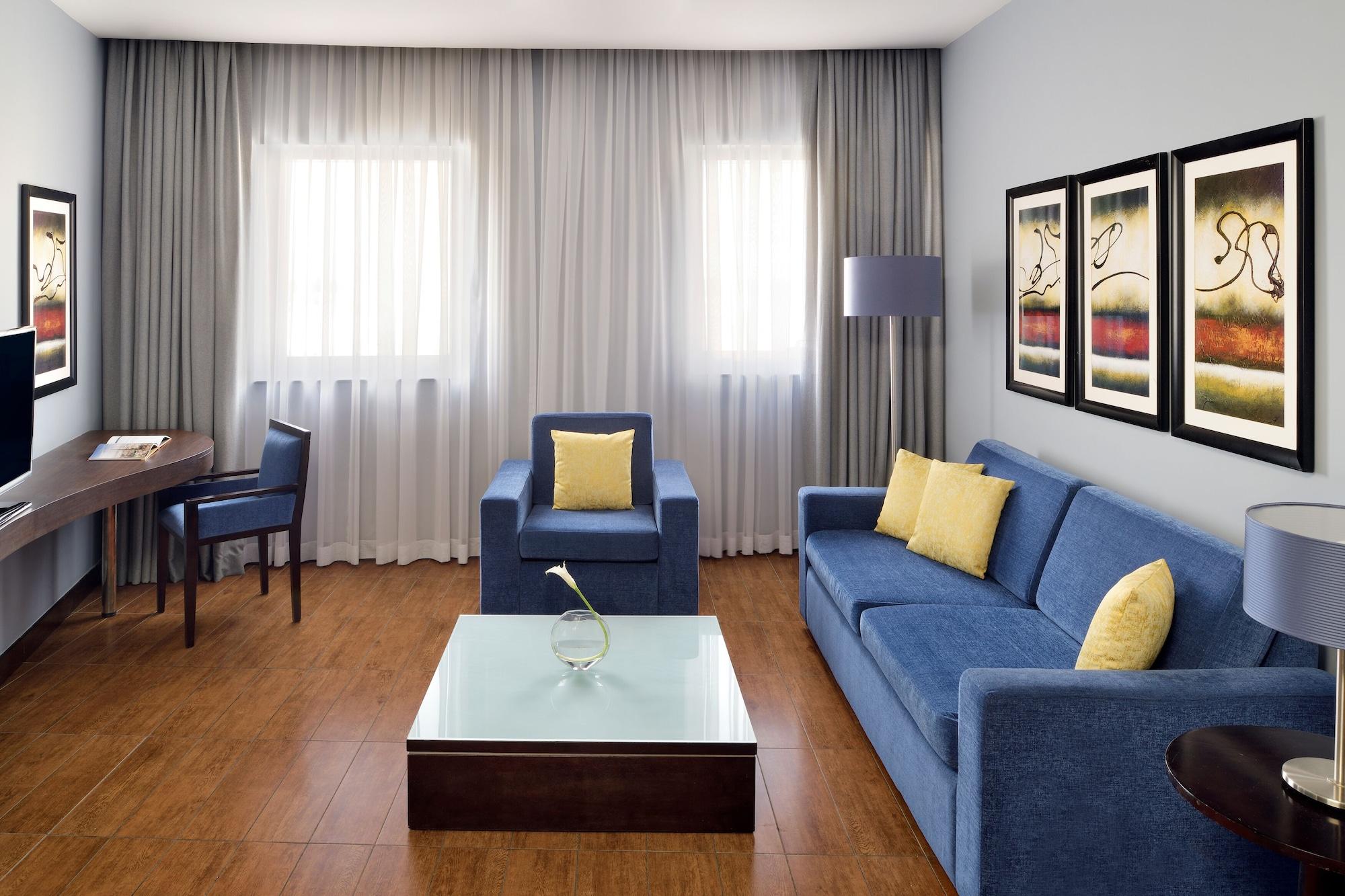 モーベンピック ホテル アパートメンツ アル マンザー ドバイ エクステリア 写真 A living room with a sofa