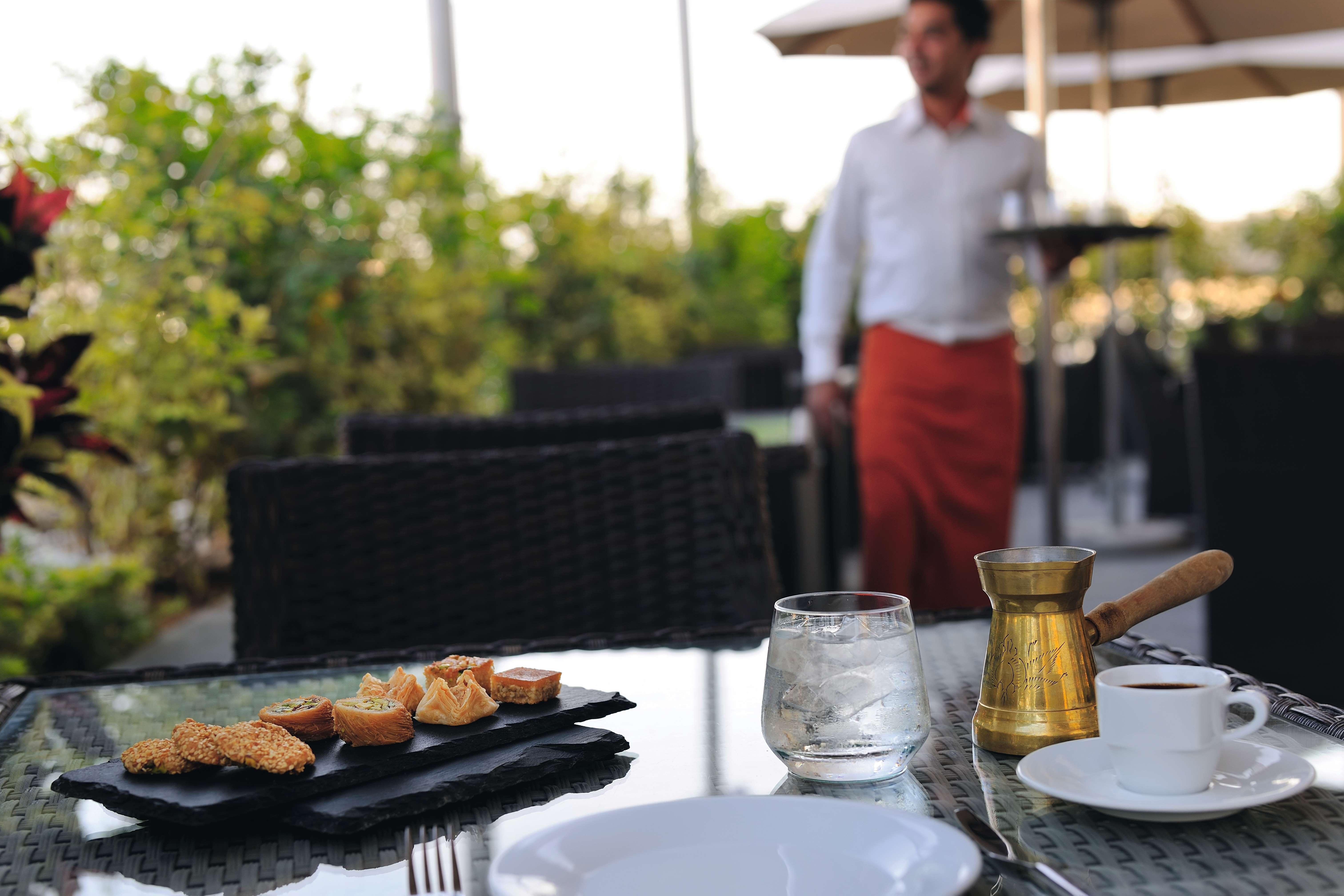 モーベンピック ホテル アパートメンツ アル マンザー ドバイ エクステリア 写真 A waiter at work